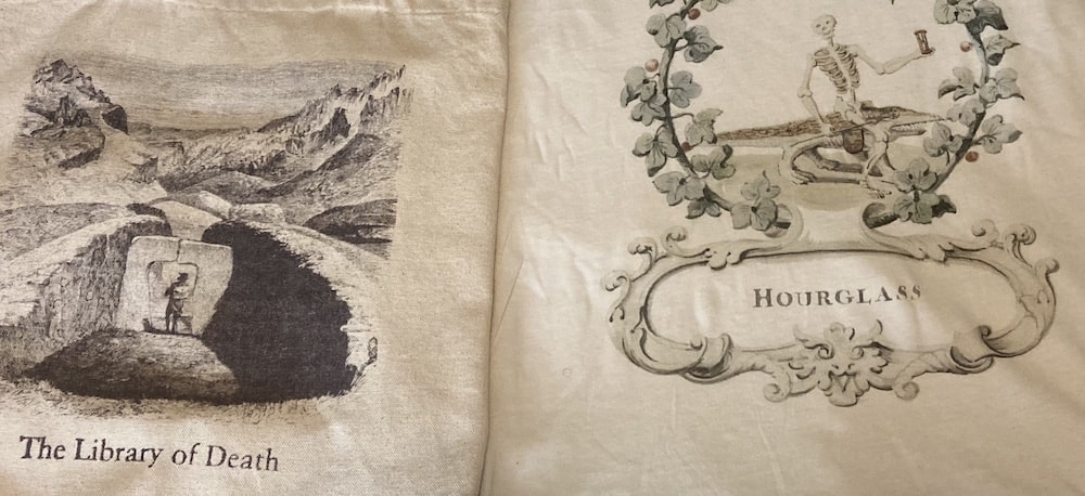 Close-up of the Library of Death tote bag and Hourglass t-shirts